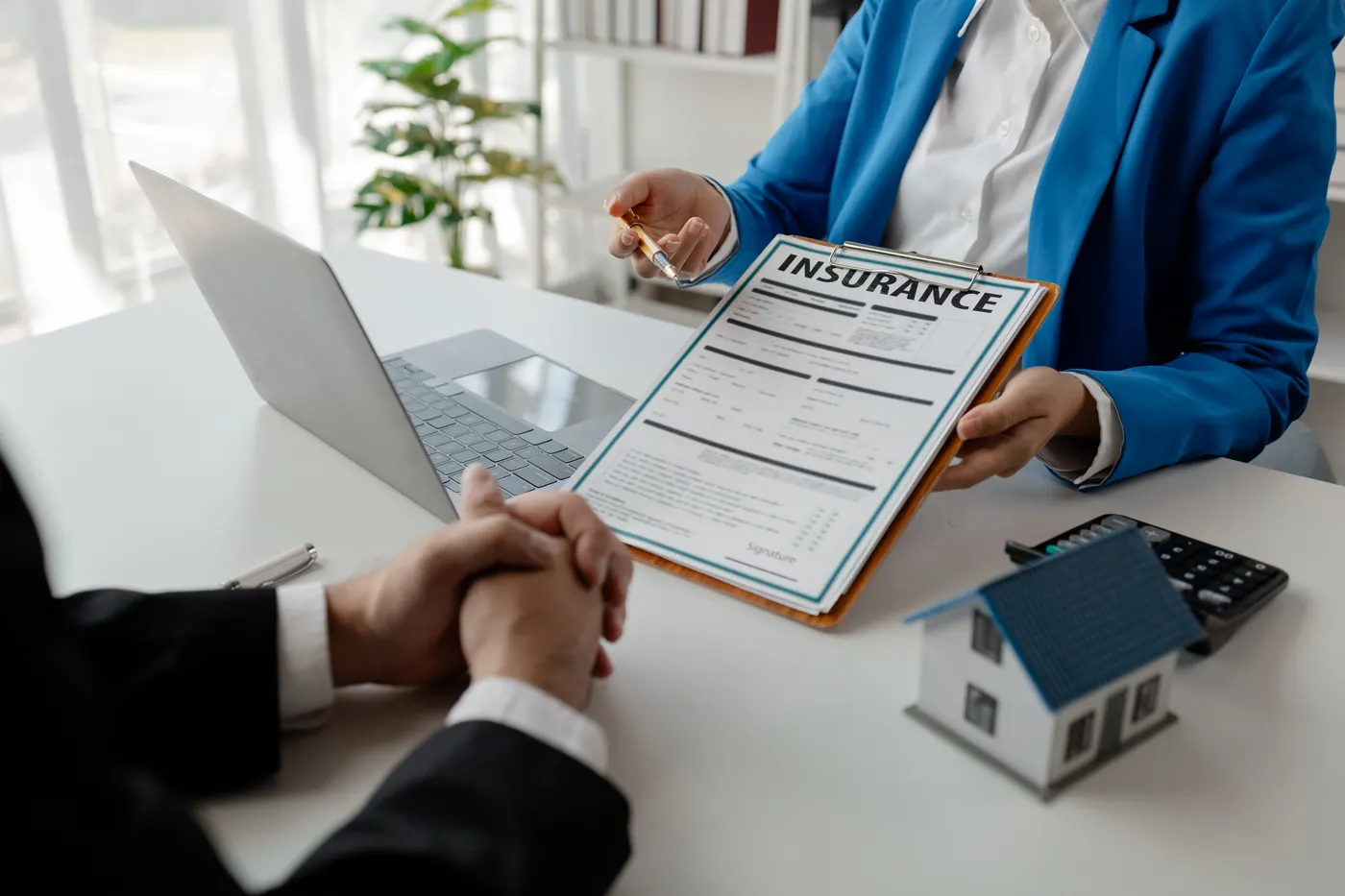 An insurance agent going over a home insurance form with a client